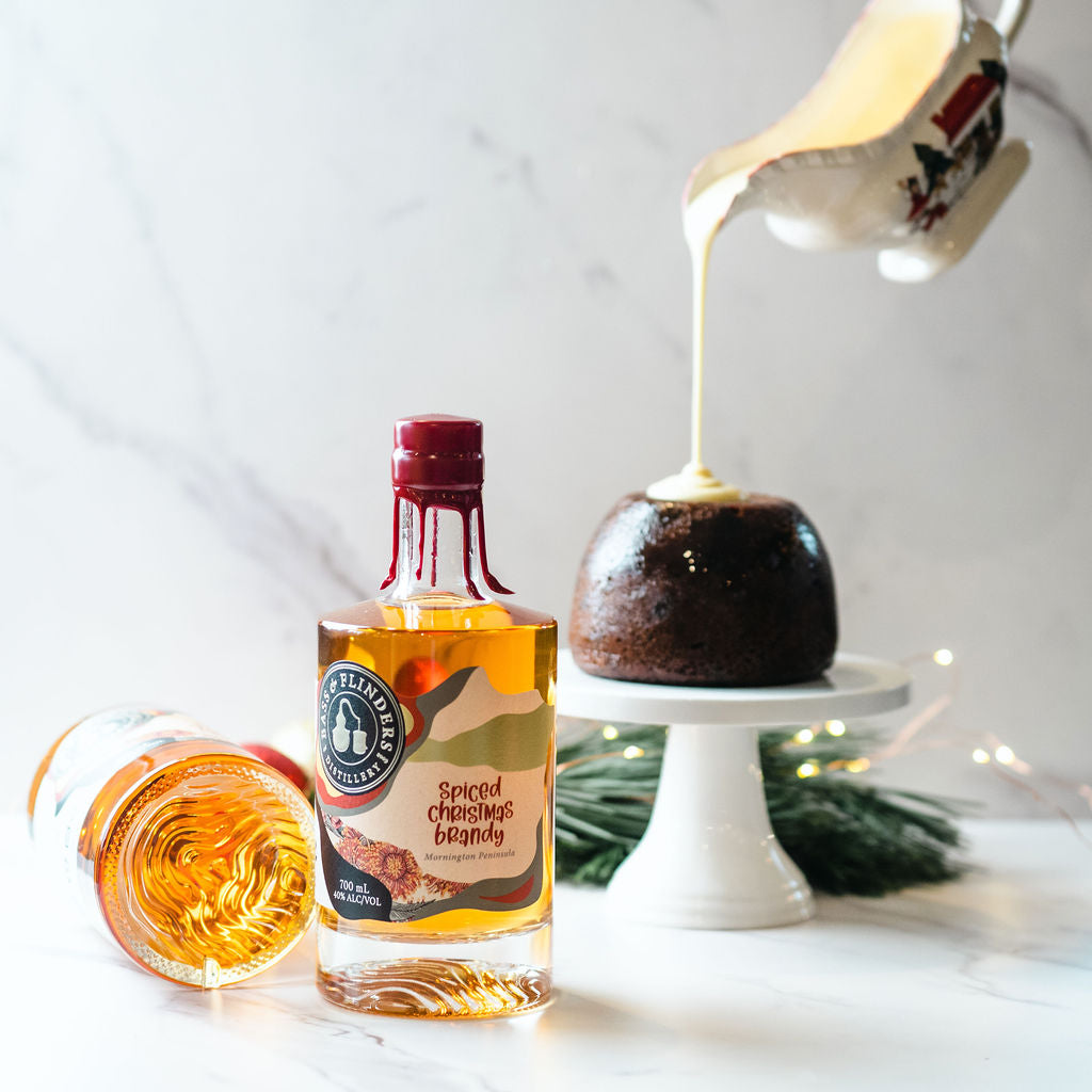 Bass & Flinders Distillery Spiced Christmas Brandy in bottle and in brandy sauce pouring over christmas pudding